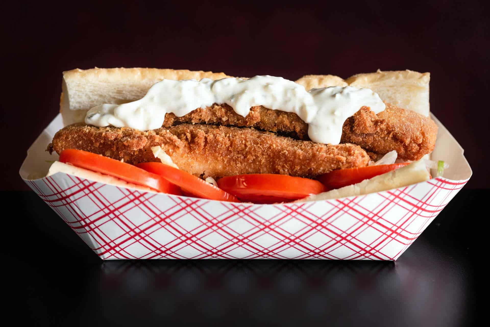 Fresh Fish Sandwich with Tartar Sauce at The Original Island Shrimp House Fresh fish sandwich with crispy breading, tomato slices, and tartar sauce at The Original Island Shr.