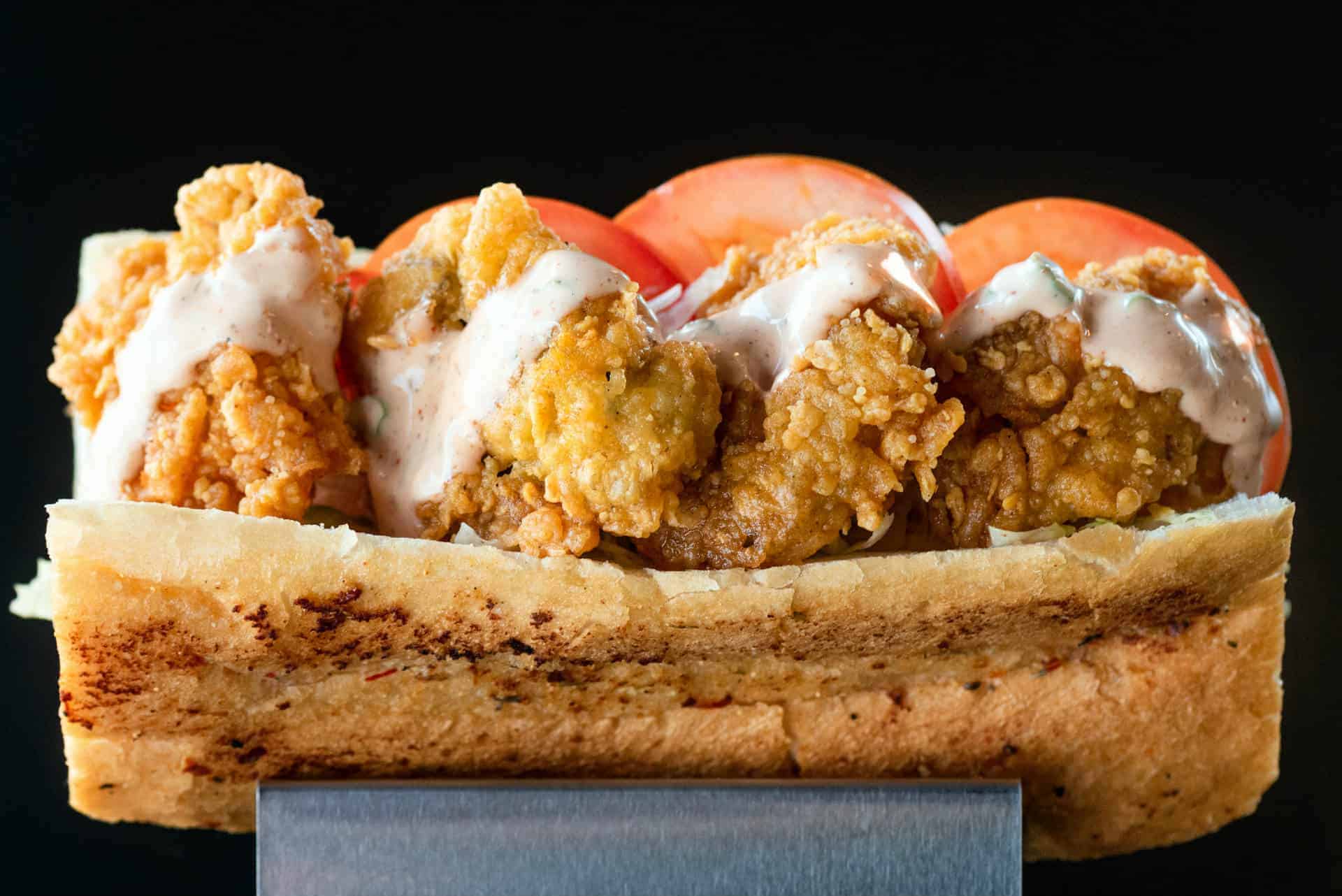 Fresh Shrimp Po’ Boy Sandwich at The Original Island Shrimp House Delicious shrimp po' boy sandwich with crispy fried shrimp, fresh tomatoes, and creamy sauce.